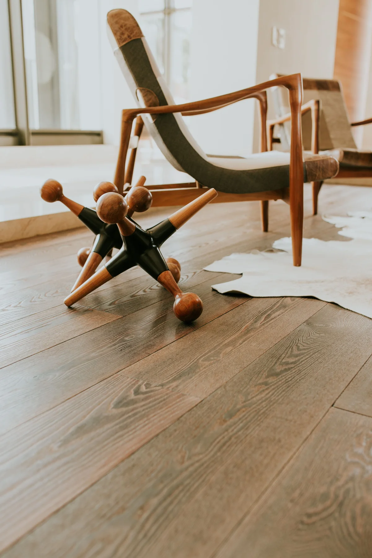 Mid-century modern armchair and wooden sculpture on a warm hardwood floor