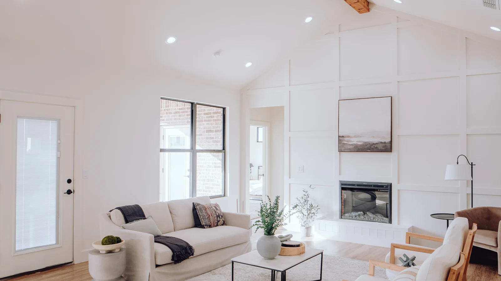 Bright modern living room with a fireplace and hardwood flooring visible at the edges