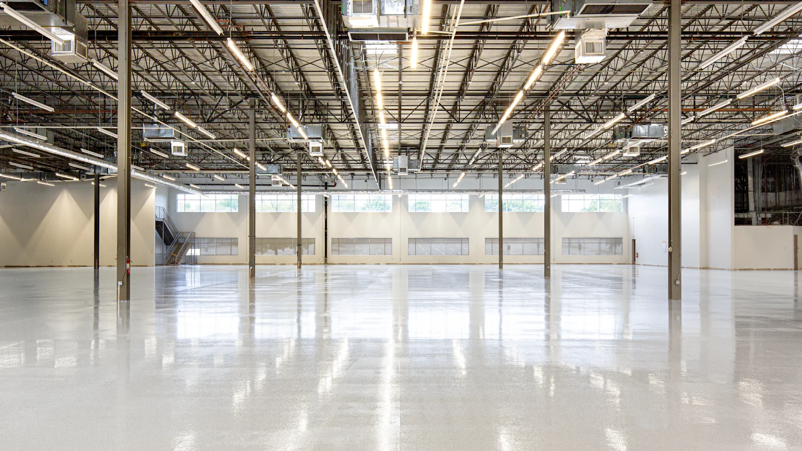 Empty commercial space with a polished concrete slab floor ready for flooring installation