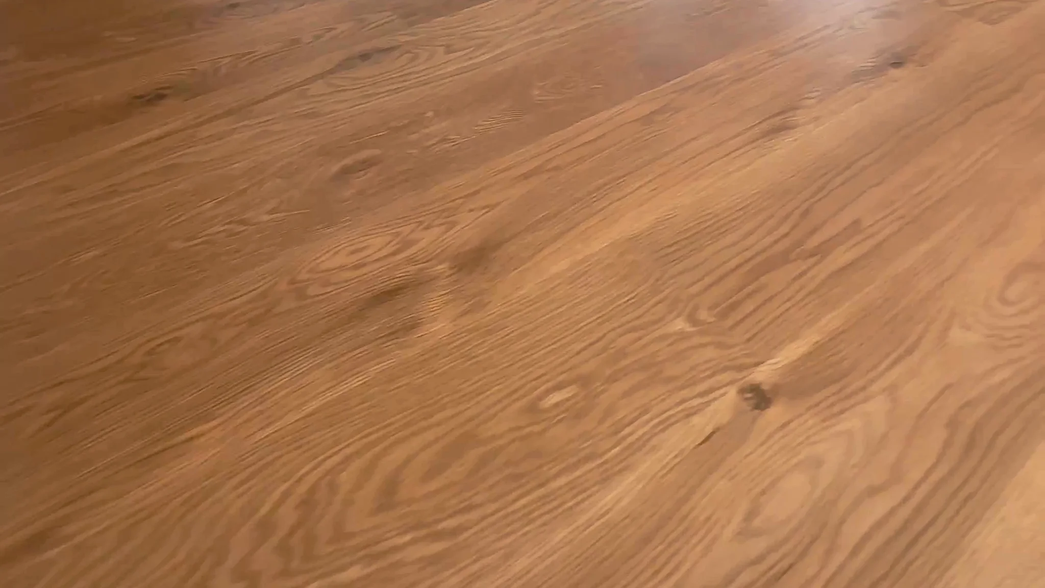 Close-up of engineered hardwood plank flooring showing the wear layer surface and grain