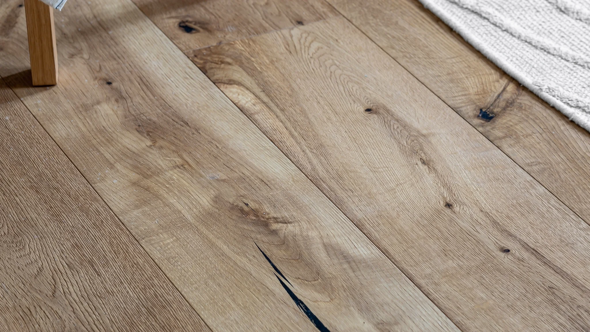 Wide-plank oak flooring with visible grain and knots in a furnished room