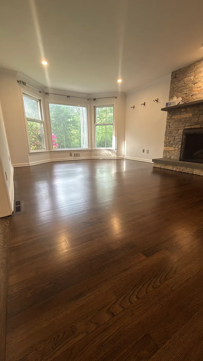Hardwood Floor by a Stacked-Stone Fireplace